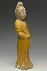 A TANG DYNASTY AMBER GLAZED FIGURE OF A COURT LADY