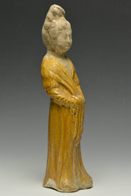 A TANG DYNASTY AMBER GLAZED FIGURE OF A COURT LADY