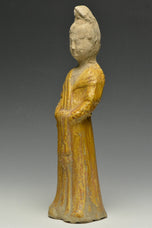 A TANG DYNASTY AMBER GLAZED FIGURE OF A COURT LADY