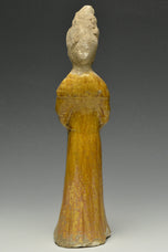 A TANG DYNASTY AMBER GLAZED FIGURE OF A COURT LADY